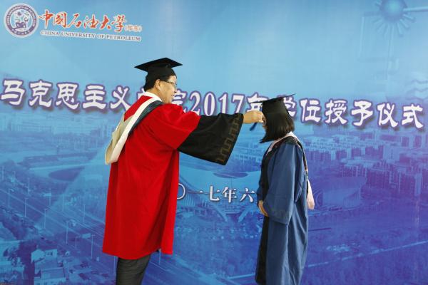 公司学位评定分委员会主席王建军经理为毕业生拨动流苏 公司学位评定分委员会主席王建军经理为毕业生拨动流苏